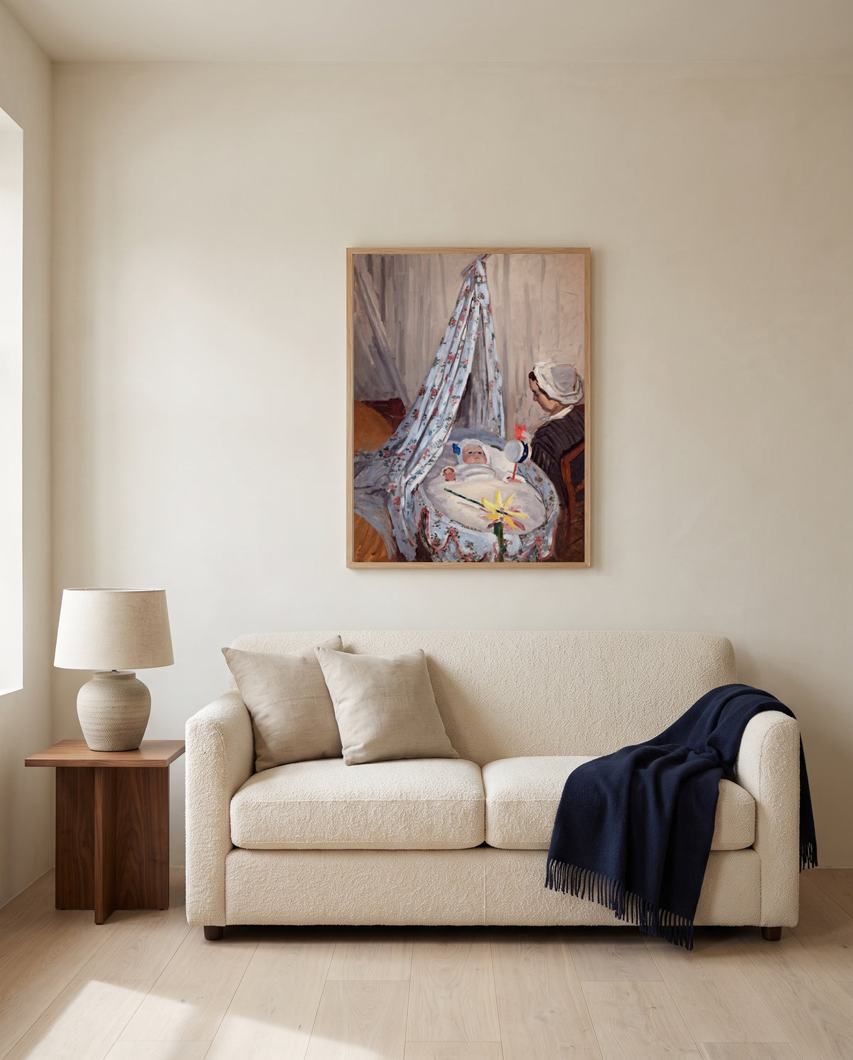 The Cradle by Claude Monet framed in natural oak above a cream sofa in a warm living room