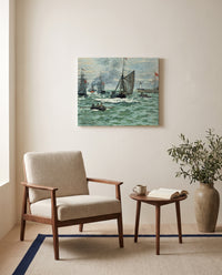 Port of Le Havre Entrance by Claude Monet as a stretched canvas above a linen lounge chair in a reading corner