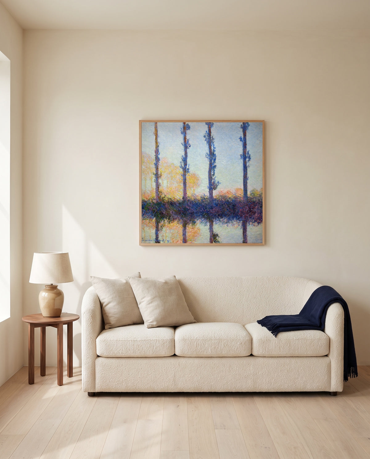 The Four Trees by Claude Monet framed in natural oak above a cream sofa in a warm living room