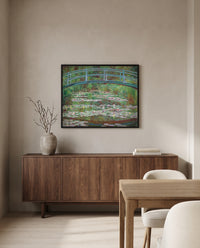 The Japanese Footbridge by Claude Monet in a black frame above a walnut sideboard in a dining room