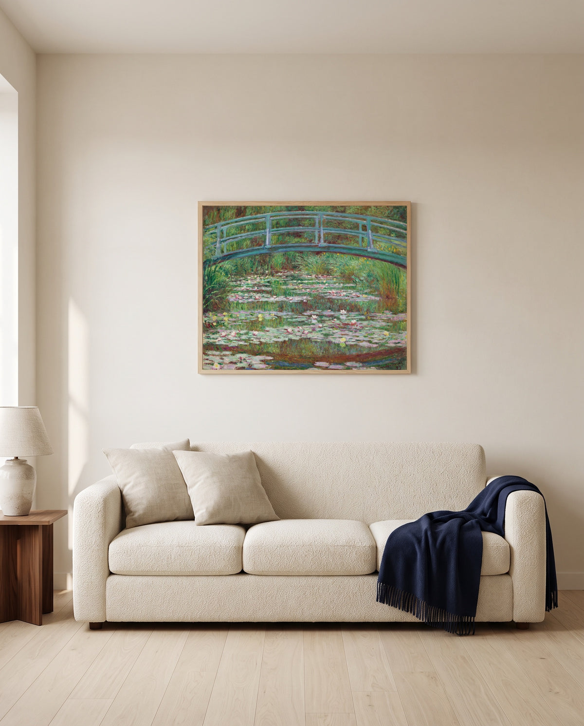 The Japanese Footbridge by Claude Monet framed in natural oak above a cream sofa in a warm living room