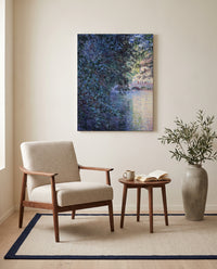 The Mill at Limetz by Claude Monet as a stretched canvas above a linen lounge chair in a reading corner