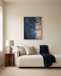 The Mill at Limetz by Claude Monet framed in natural oak above a cream sofa in a warm living room