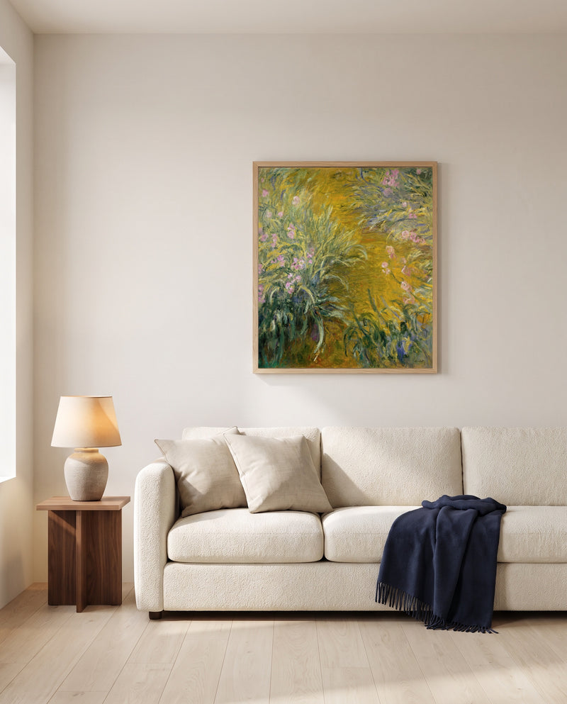 The Path through the Irises by Claude Monet framed in natural oak above a cream sofa in a warm living room
