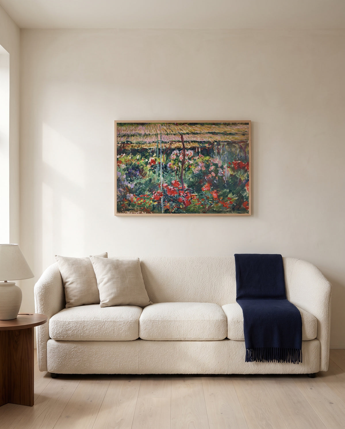 The Peony Garden by Claude Monet framed in natural oak above a cream sofa in a warm living room