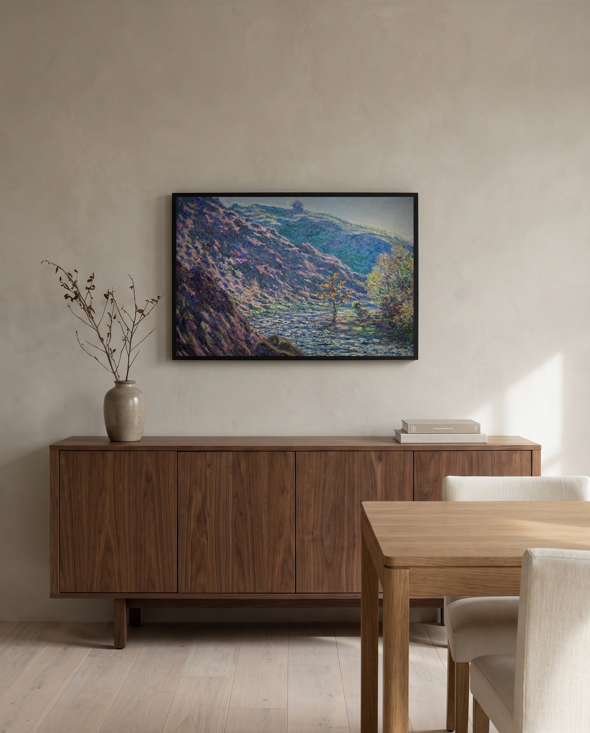 The Petite Creuse River by Claude Monet in a black frame above a walnut sideboard in a dining room