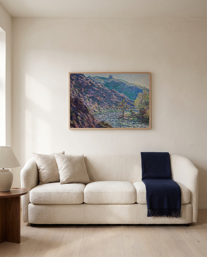 The Petite Creuse River by Claude Monet framed in natural oak above a cream sofa in a warm living room