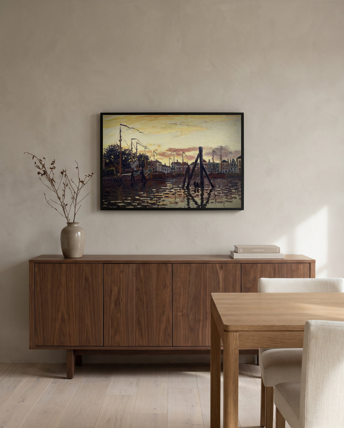 The Port of Zaandam by Claude Monet in a black frame above a walnut sideboard in a dining room
