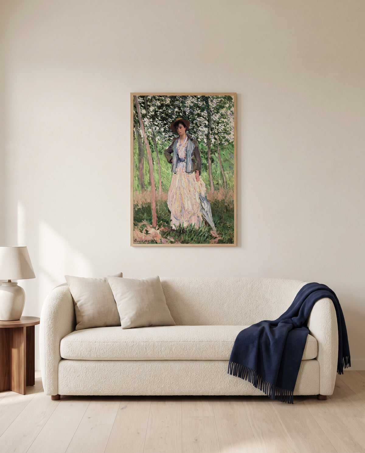The Stroller by Claude Monet framed in natural oak above a cream sofa in a warm living room