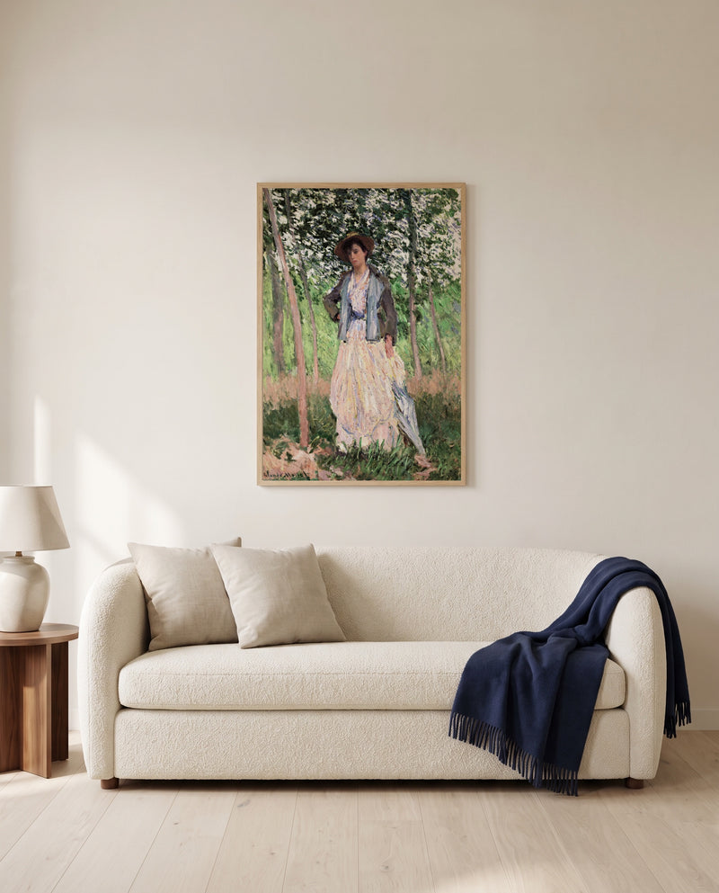 The Stroller by Claude Monet framed in natural oak above a cream sofa in a warm living room