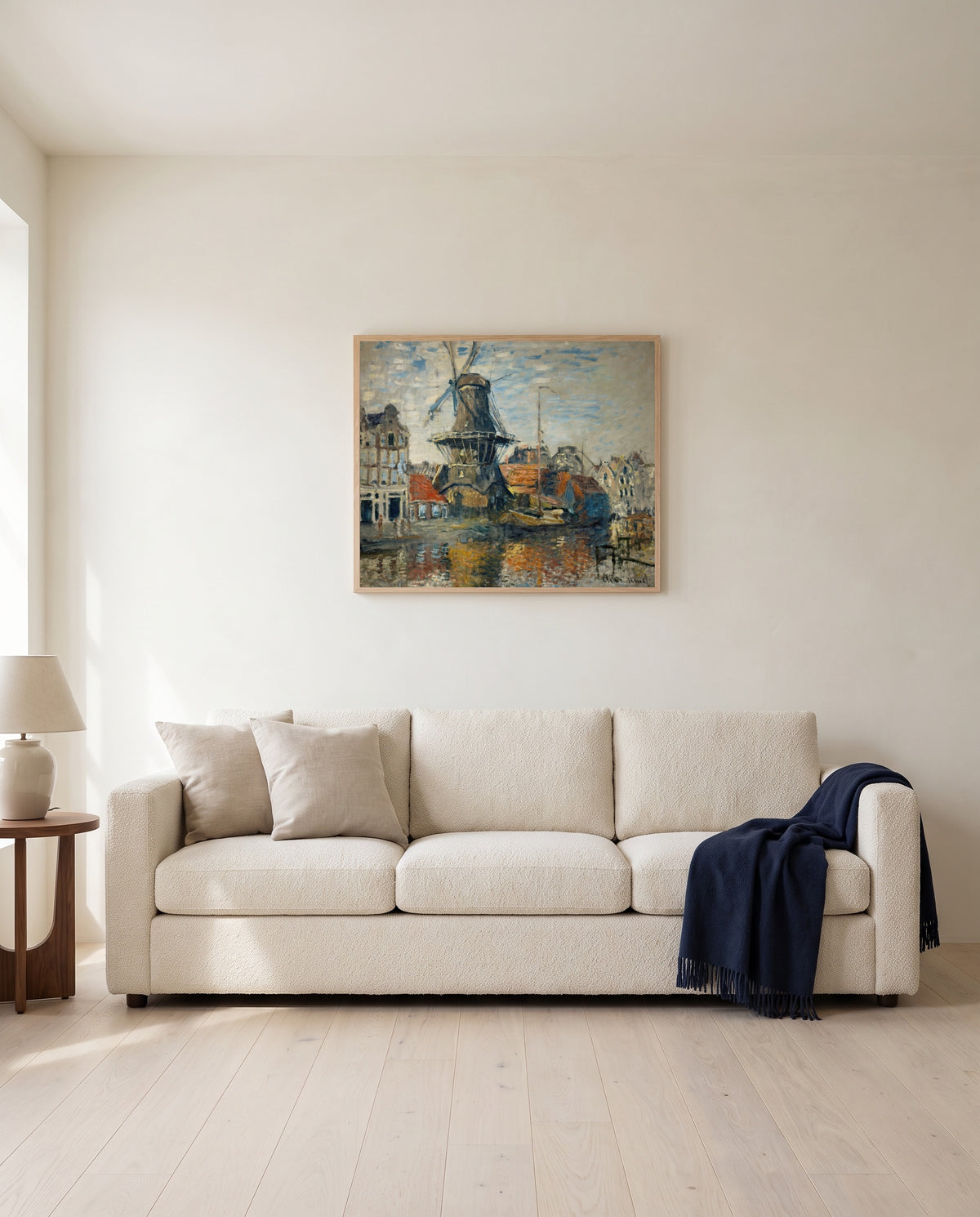 Windmill, Amsterdam by Claude Monet framed in natural oak above a cream sofa in a warm living room