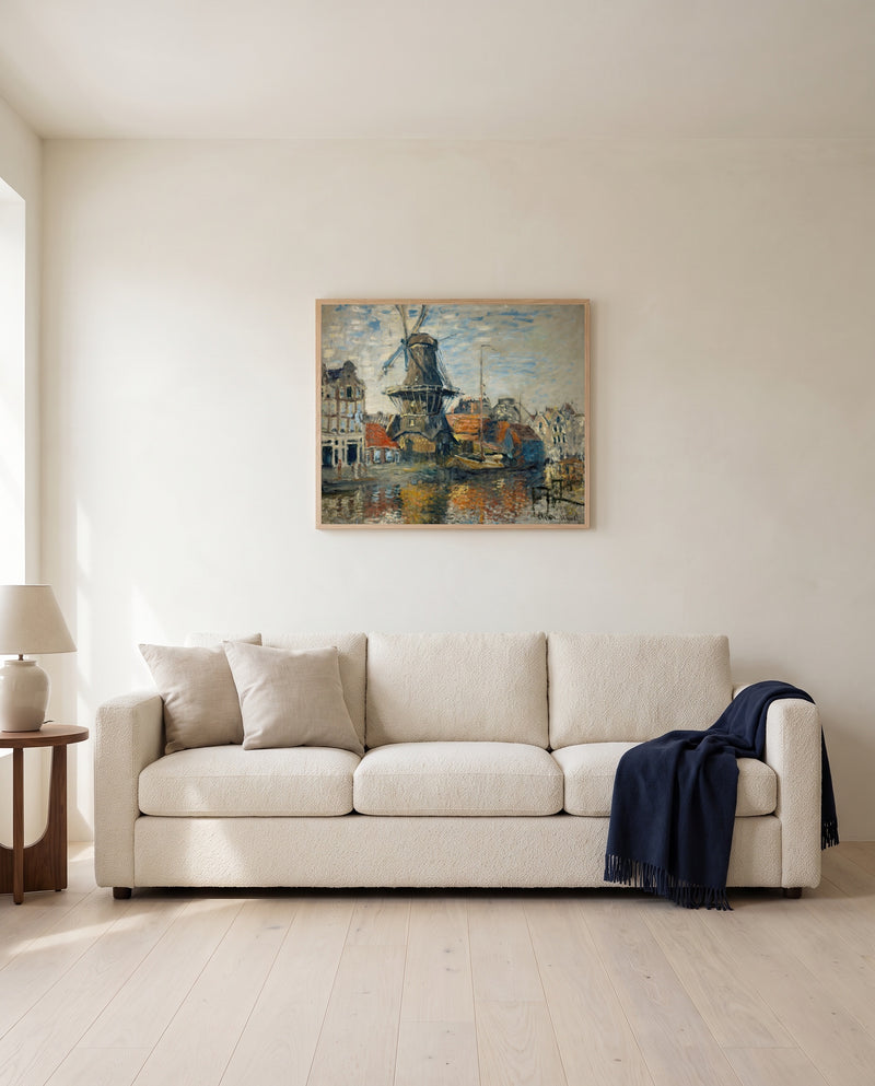 Windmill, Amsterdam by Claude Monet framed in natural oak above a cream sofa in a warm living room