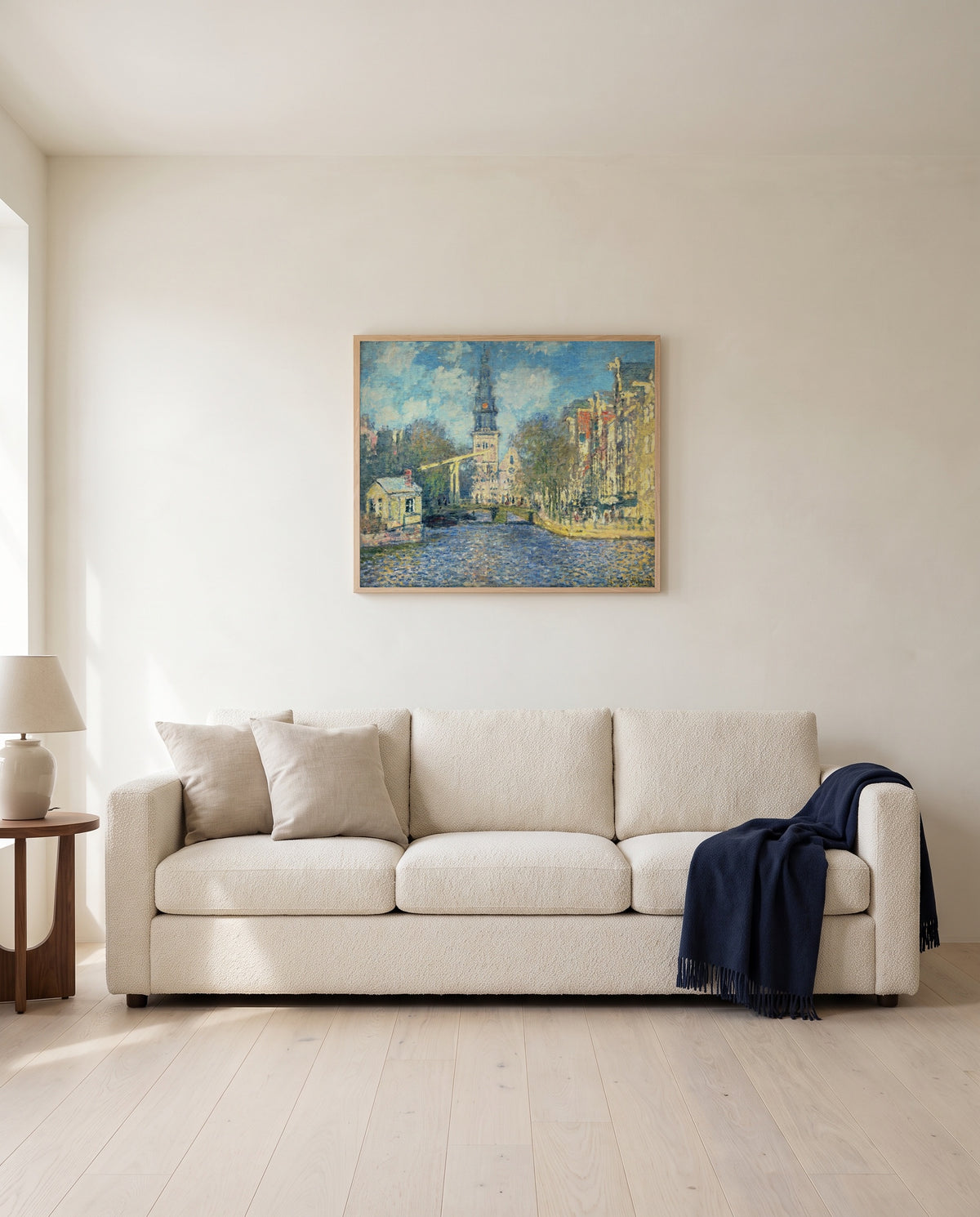The Zuiderkerk, Amsterdam by Claude Monet framed in natural oak above a cream sofa in a warm living room