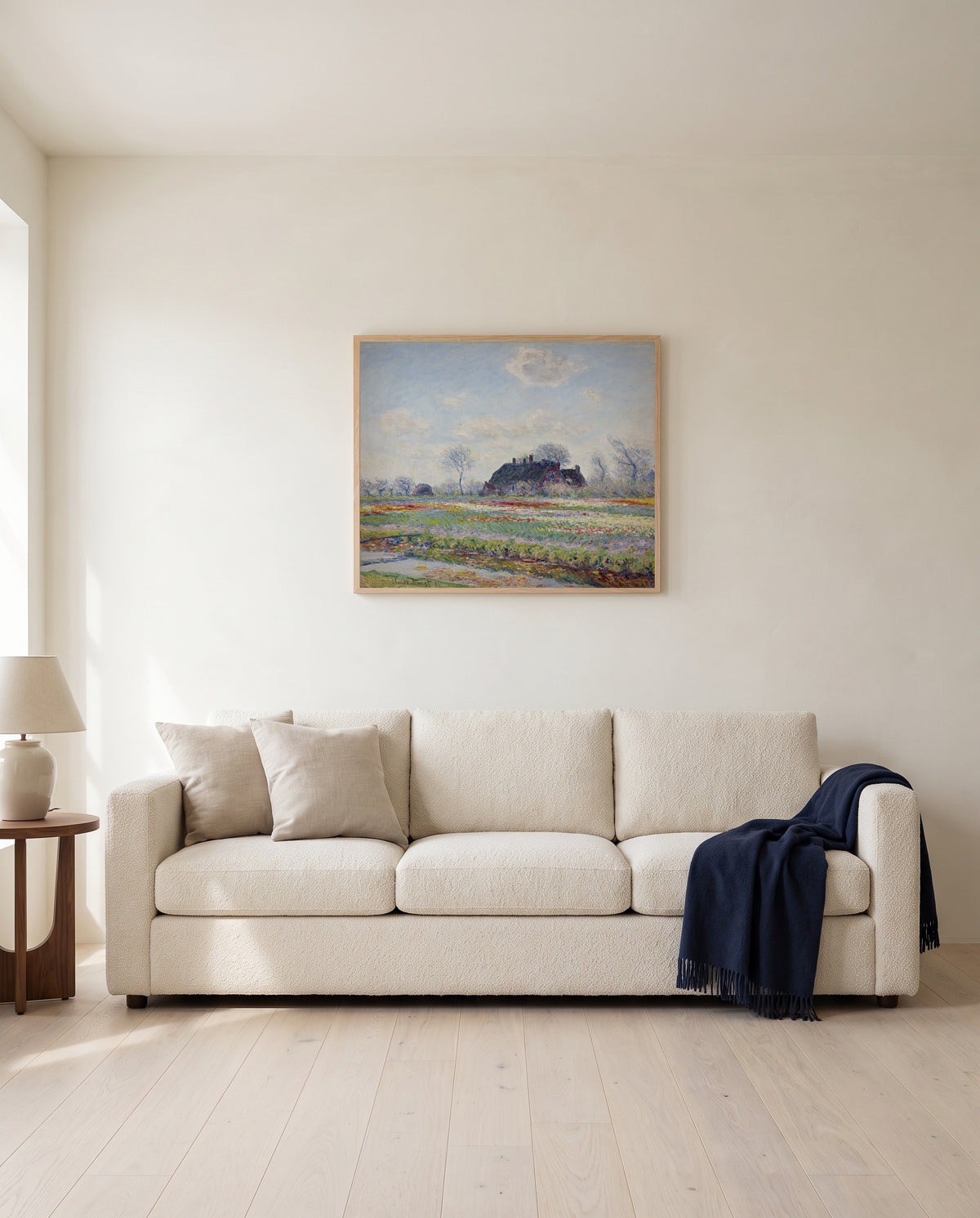 Tulip Fields at Sassenheim by Claude Monet framed in natural oak above a cream sofa in a warm living room