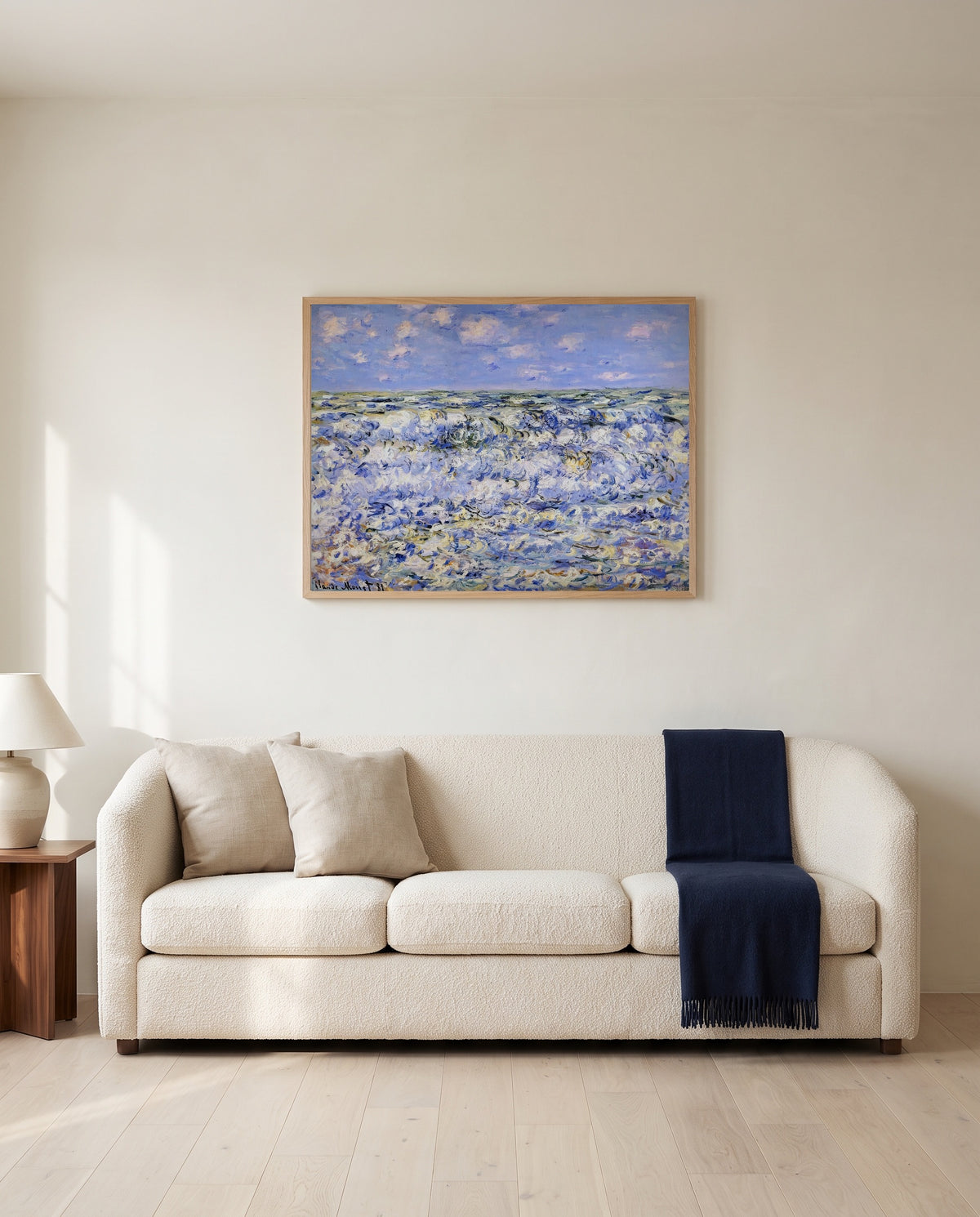Waves Breaking by Claude Monet framed in natural oak above a cream sofa in a warm living room