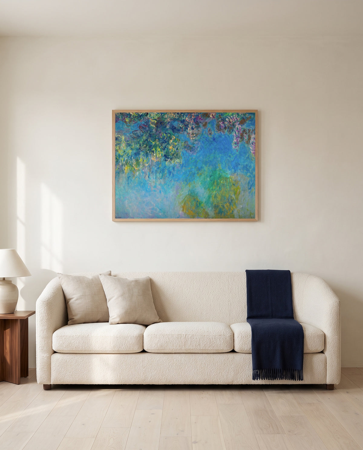 Wisteria by Claude Monet framed in natural oak above a cream sofa in a warm living room