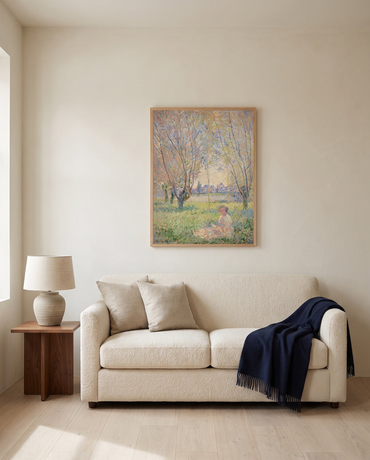 Woman under the Willows by Claude Monet framed in natural oak above a cream sofa in a warm living room