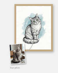 The customer's photo laid on the corner of the finished custom illustrated cat portrait, framed in natural wood