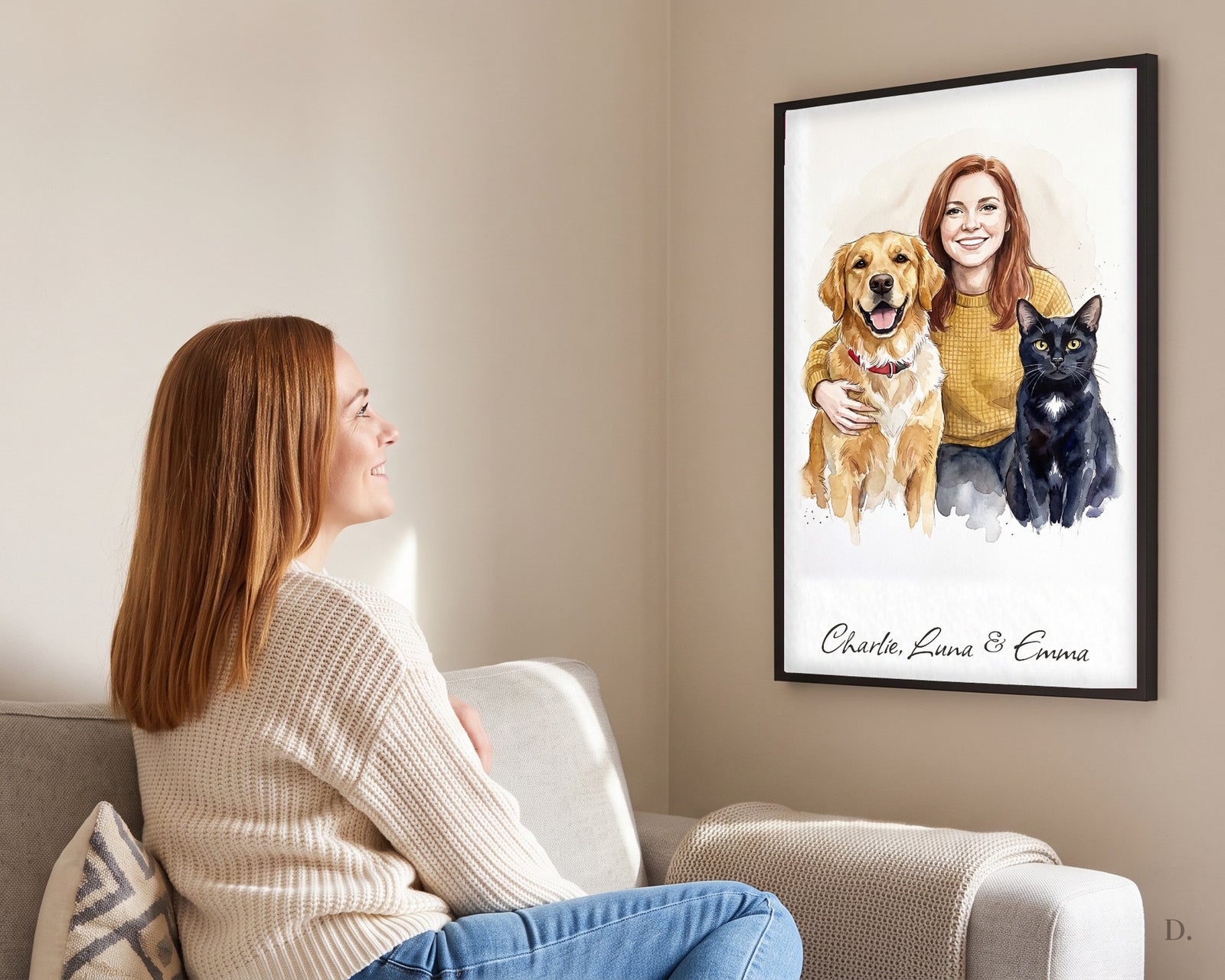 Woman on a sofa with her framed watercolor portrait of herself, her golden retriever and her black cat, in a slim black frame