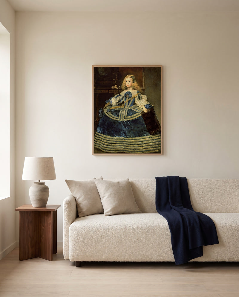Infanta in a Blue Dress by Diego Velázquez framed in natural oak above a cream sofa in a warm living room