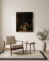 Las Meninas by Diego Velázquez as a stretched canvas above a linen lounge chair in a reading corner
