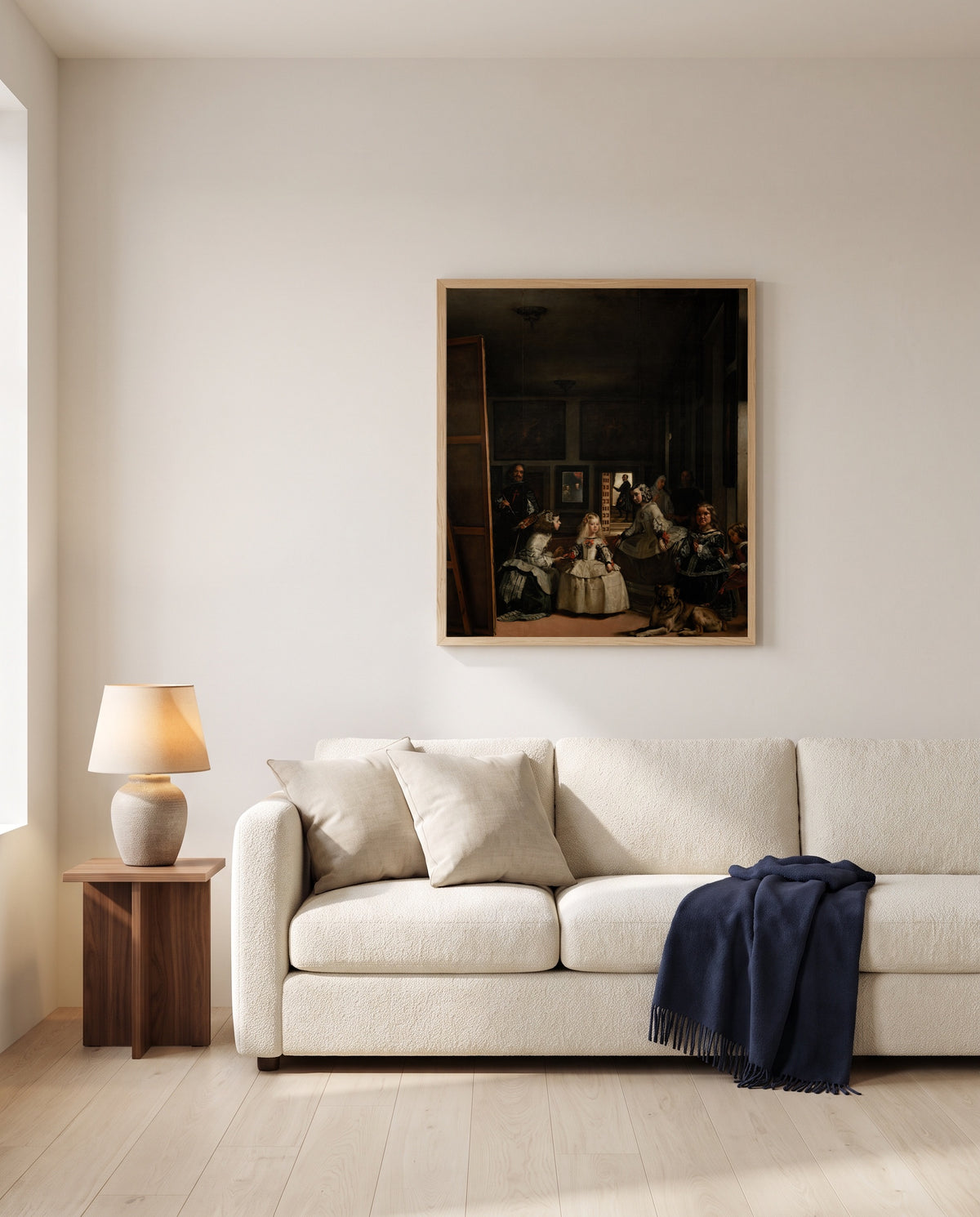 Las Meninas by Diego Velázquez framed in natural oak above a cream sofa in a warm living room