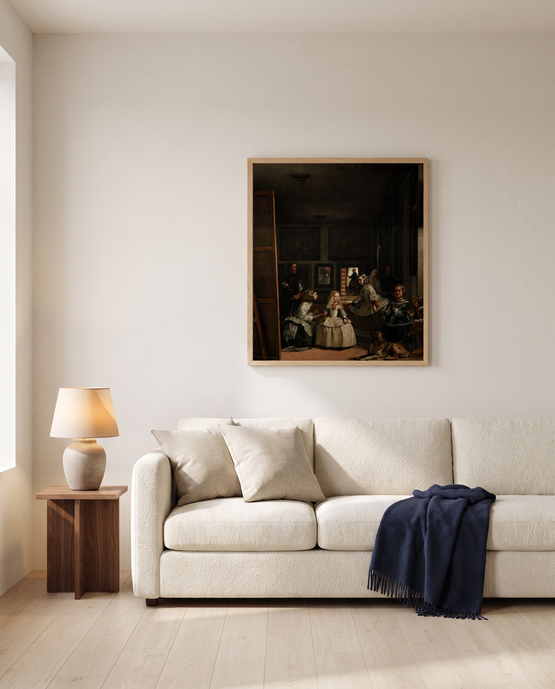 Las Meninas by Diego Velázquez framed in natural oak above a cream sofa in a warm living room
