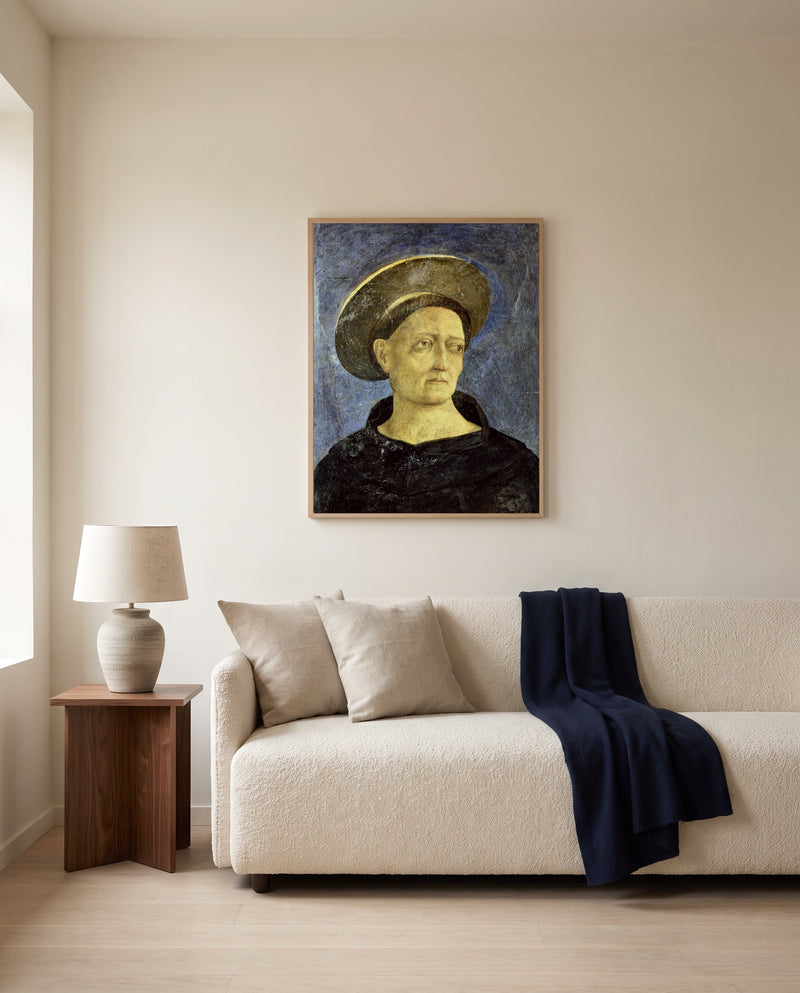 Head of a Beardless Saint by Domenico Veneziano framed in natural oak above a cream sofa in a warm living room
