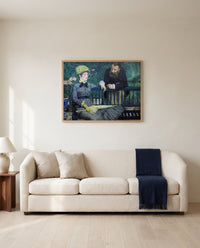In the Conservatory by Édouard Manet framed in natural oak above a cream sofa in a warm living room