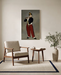 The Fifer by Édouard Manet as a stretched canvas above a linen lounge chair in a reading corner