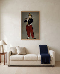 The Fifer by Édouard Manet framed in natural oak above a cream sofa in a warm living room