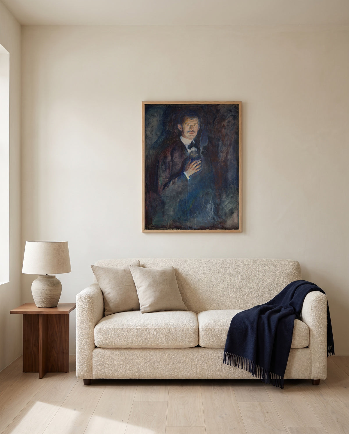 Self-Portrait with Cigarette by Edvard Munch framed in natural oak above a cream sofa in a warm living room