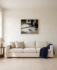 Night Shadows by Edward Hopper framed in natural oak above a cream sofa in a warm living room
