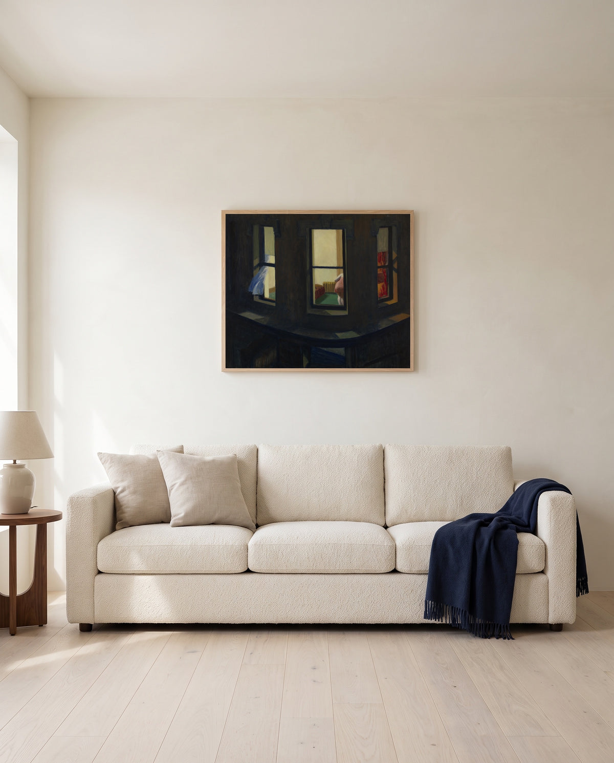 Night Windows by Edward Hopper framed in natural oak above a cream sofa in a warm living room