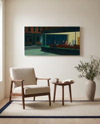Nighthawks by Edward Hopper as a stretched canvas above a linen lounge chair in a reading corner