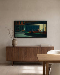 Nighthawks by Edward Hopper in a black frame above a walnut sideboard in a dining room