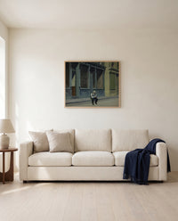 Sunday by Edward Hopper framed in natural oak above a cream sofa in a warm living room