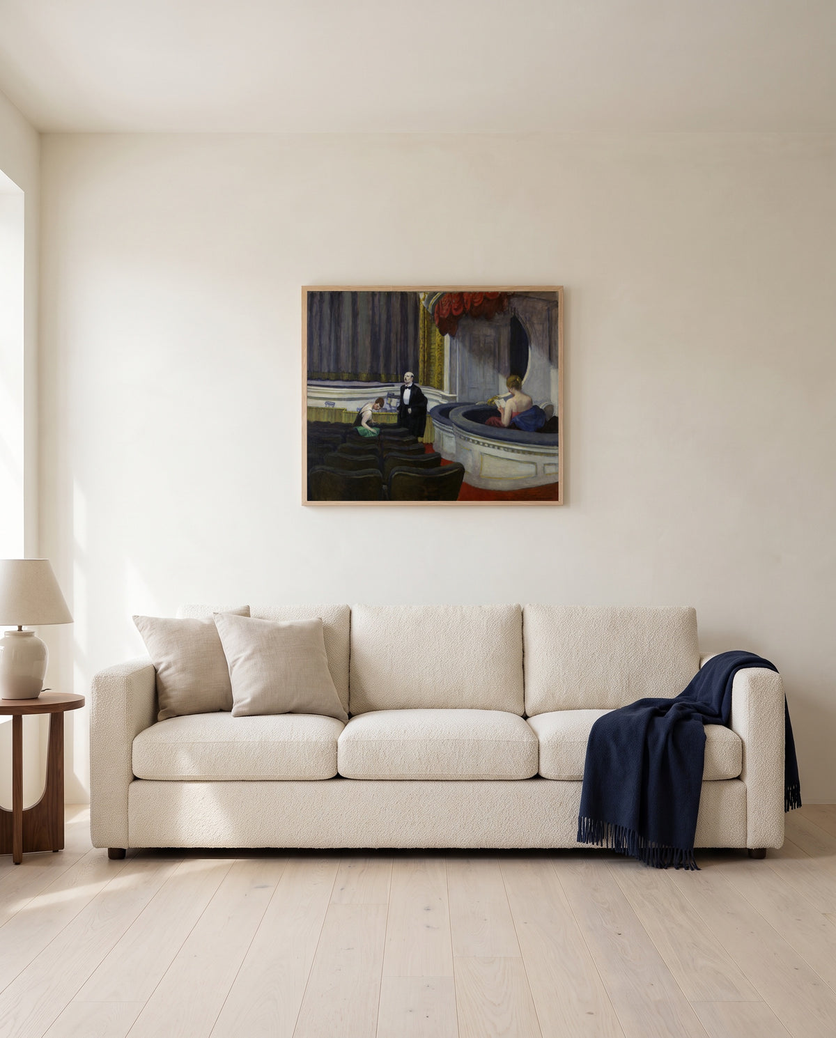 Two on the Aisle by Edward Hopper framed in natural oak above a cream sofa in a warm living room