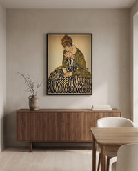 Edith in a Striped Dress by Egon Schiele in a black frame above a walnut sideboard in a dining room