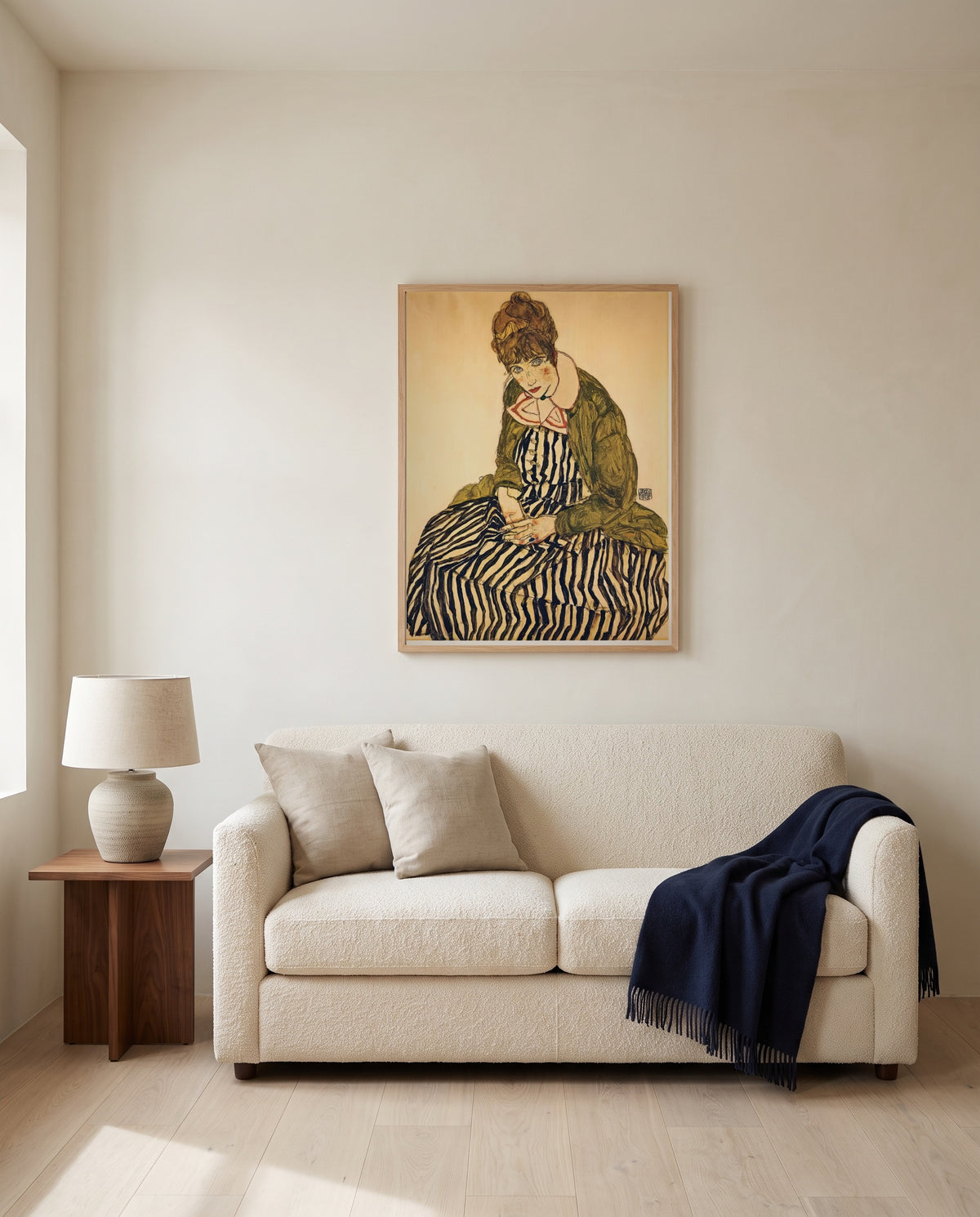 Edith in a Striped Dress (Vienna) by Egon Schiele framed in natural oak above a cream sofa in a warm living room