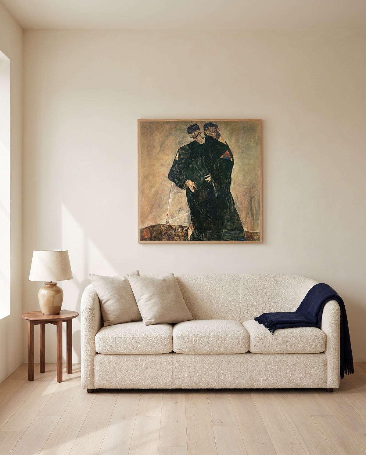 Hermits by Egon Schiele framed in natural oak above a cream sofa in a warm living room