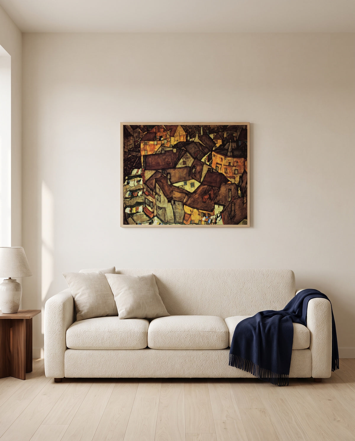Krumau Town Crescent I by Egon Schiele framed in natural oak above a cream sofa in a warm living room