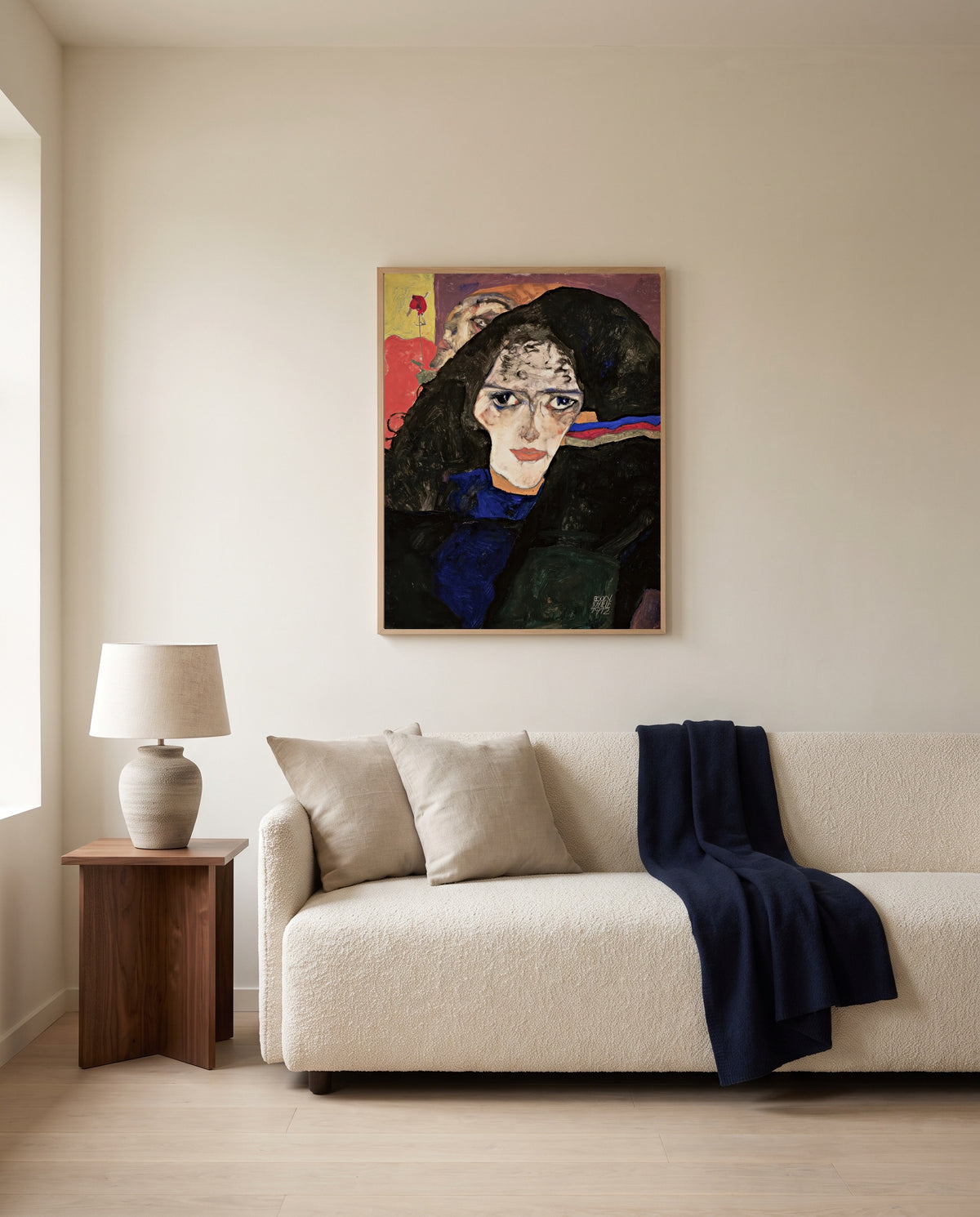 Mourning Woman by Egon Schiele framed in natural oak above a cream sofa in a warm living room