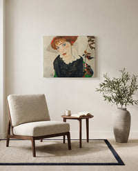 Portrait of Wally by Egon Schiele as a stretched canvas above a linen lounge chair in a reading corner