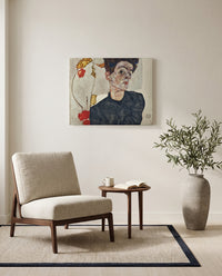 Self-Portrait with Physalis by Egon Schiele as a stretched canvas above a linen lounge chair in a reading corner