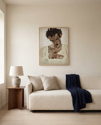 Self-Portrait, Lowered Head by Egon Schiele framed in natural oak above a cream sofa in a warm living room