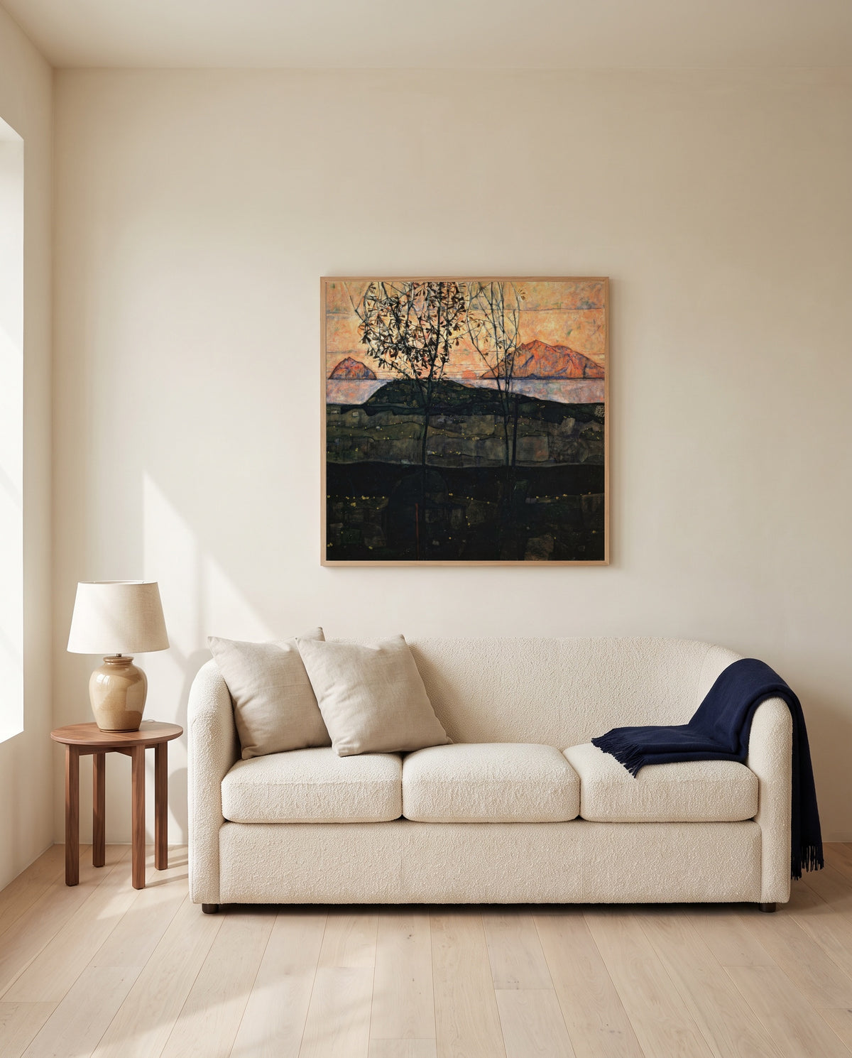 Setting Sun by Egon Schiele framed in natural oak above a cream sofa in a warm living room
