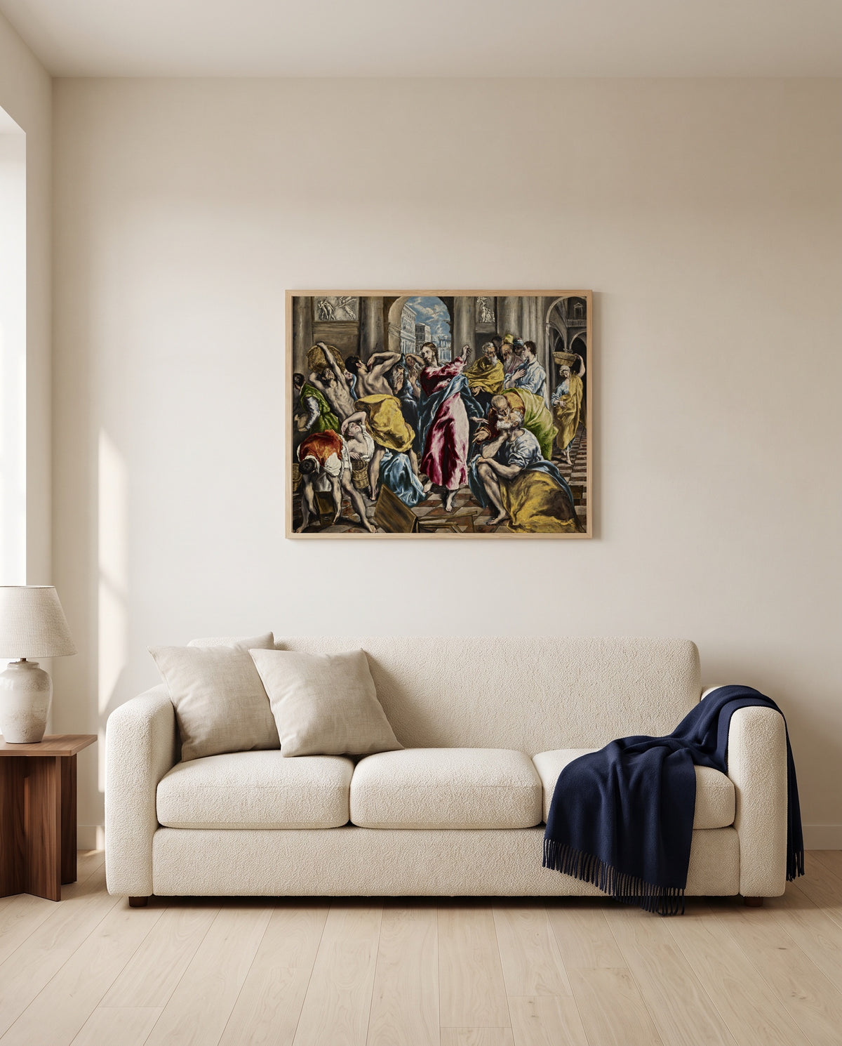 Money Changers by El Greco framed in natural oak above a cream sofa in a warm living room