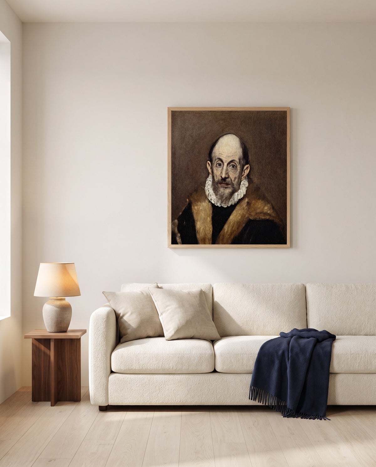 Portrait of an Old Man by El Greco framed in natural oak above a cream sofa in a warm living room