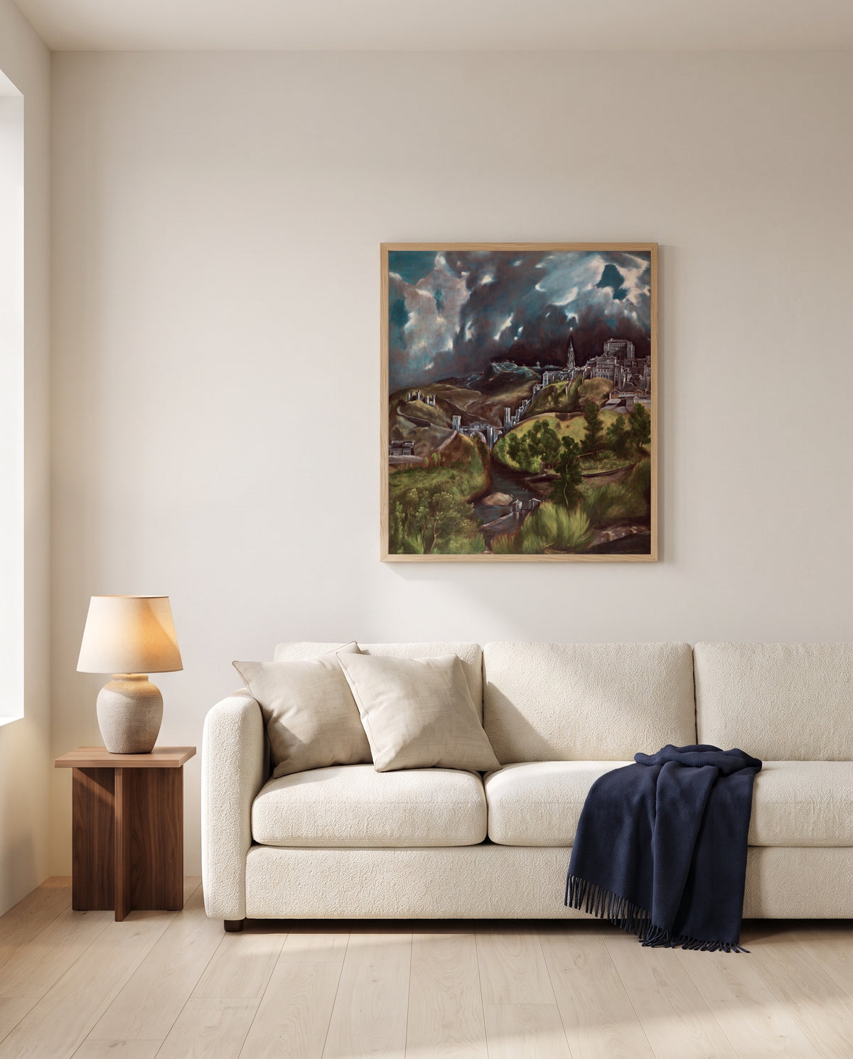 View of Toledo by El Greco framed in natural oak above a cream sofa in a warm living room